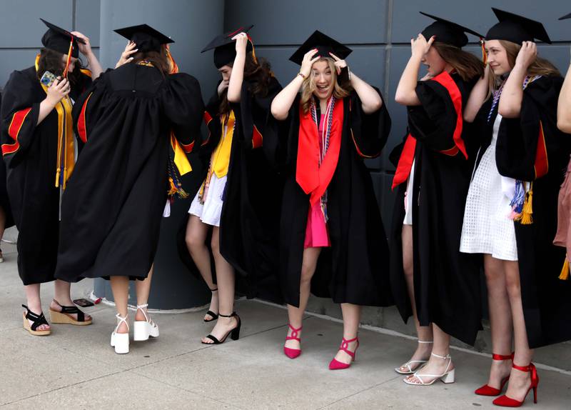 Batavia High School graduates brace for a gust of wind while taking photographs prior to the school’s 2023 commencement ceremony at Northern Illinois University in DeKalb on Wednesday, May 24, 2023.