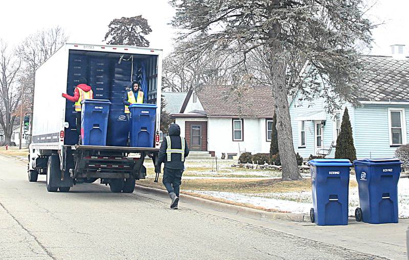 Employees with Lakeshore Recycling Services distribute garbage and recycable containers to homes along Chartres Street on Monday, Jan. 23, 2023 in La Salle. The rate will go from $14.50 per month to $20 per month with LRS. LRS is based out of Chicago, but it has a branch in Monmouth where La Salle residents will get their service.