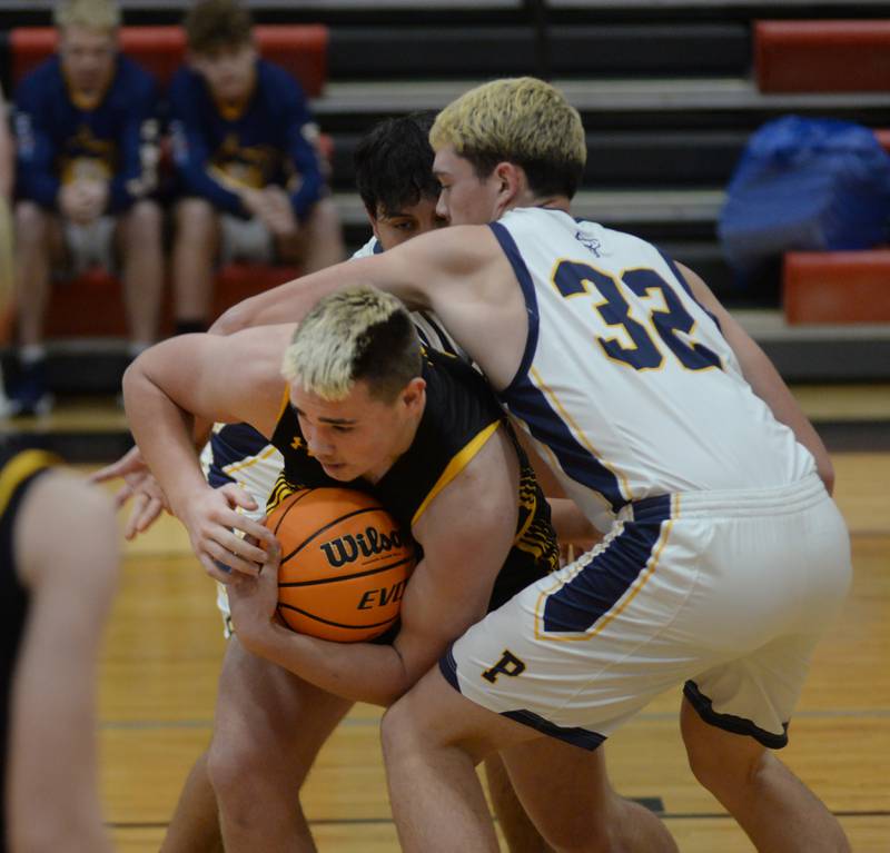 Polo's Korbin Cavanaugh (32) reaches around Lena-Winslow's Jaden Schubert (4) to try and get the basketball on Wednesday, Dec. 18, 2024 at the 63rd Annual Forreston Holiday Tournament.