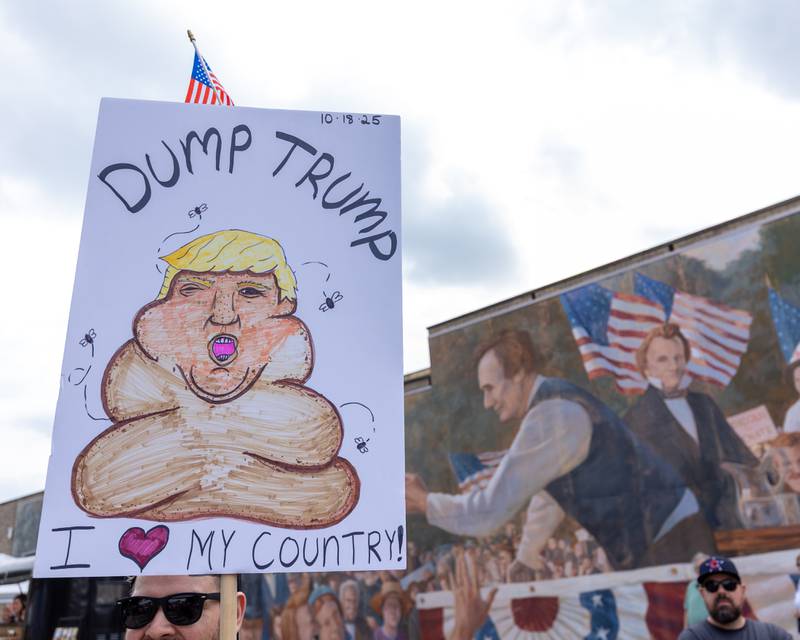 Protester holds sign above head at the ‘No Kings 2.0’ Protest on Saturday, October 18, 2025 at Washington Square Park in Ottawa.