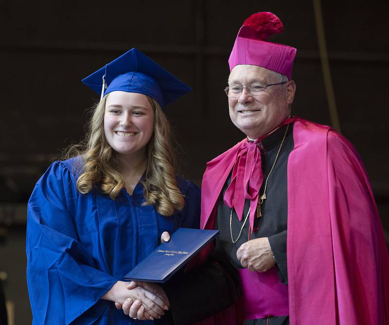 Brooklyn Zigler poses with Bishop David Malloy Wednesday, May 17, 2023 at Newman High School’s graduation.