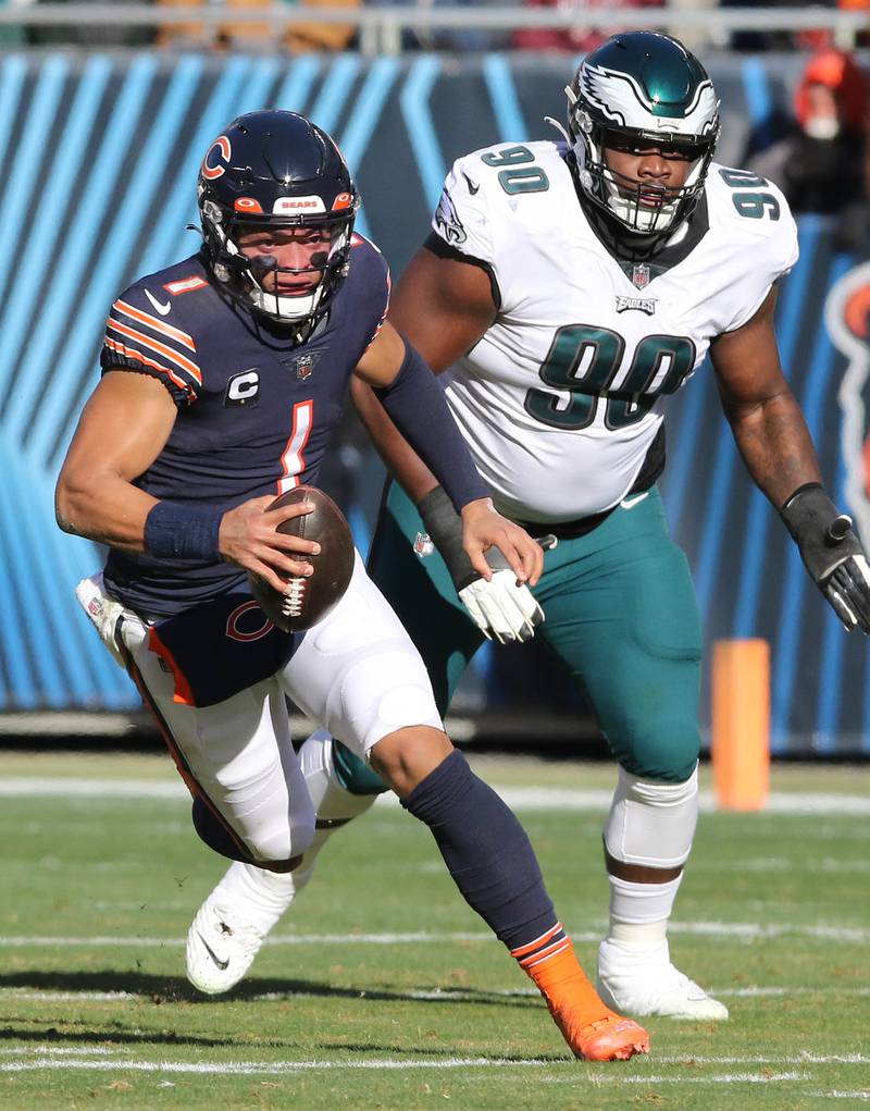 Chicago Bears quarterback Justin Fields scrambles away from Philadelphia Eagles defensive tackle Jordan Davis during their game Sunday, Dec. 18, 2022, at Soldier Field in Chicago.