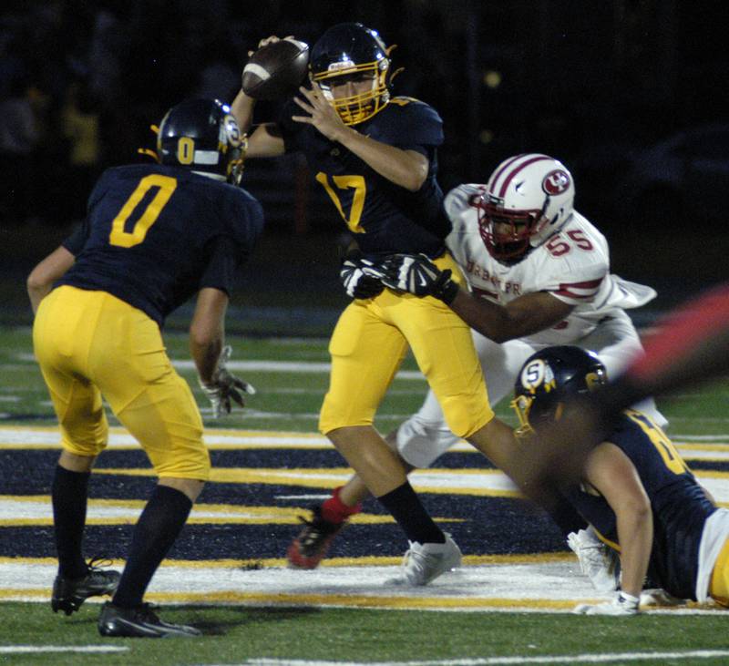 Sterling Quarterback Brady Berlin is brought down by a n Urban Prep defended .The Lions of Urban Prep traveled to Sterling to take on the Warriors at Prescott Memorial Field at Roscoe Eades Stadium, September 5, 2025.