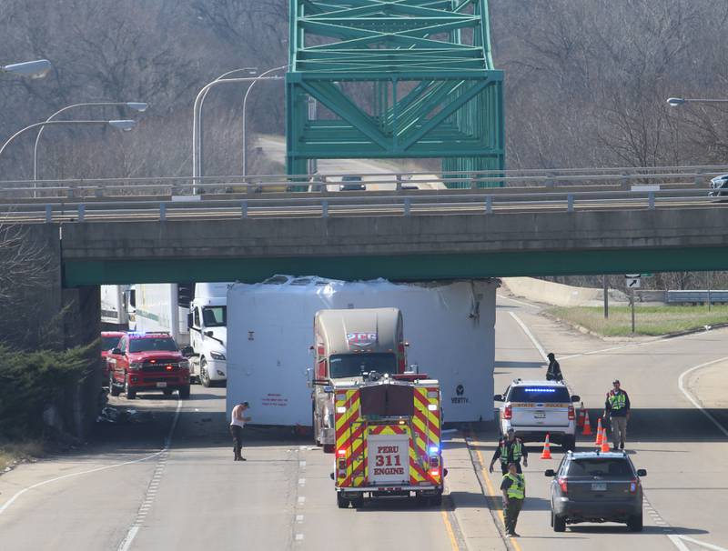 Peru firefighters work the scene of a semi truck that struck the U.S. Route 6 overpass on Monday, March 30, 2026 in Peru. Traffic was closed in both northbound and southbound directions on Illinios Route 251. Peru Police and Fire were on the scene. The incident happened shortly before 10a.m.