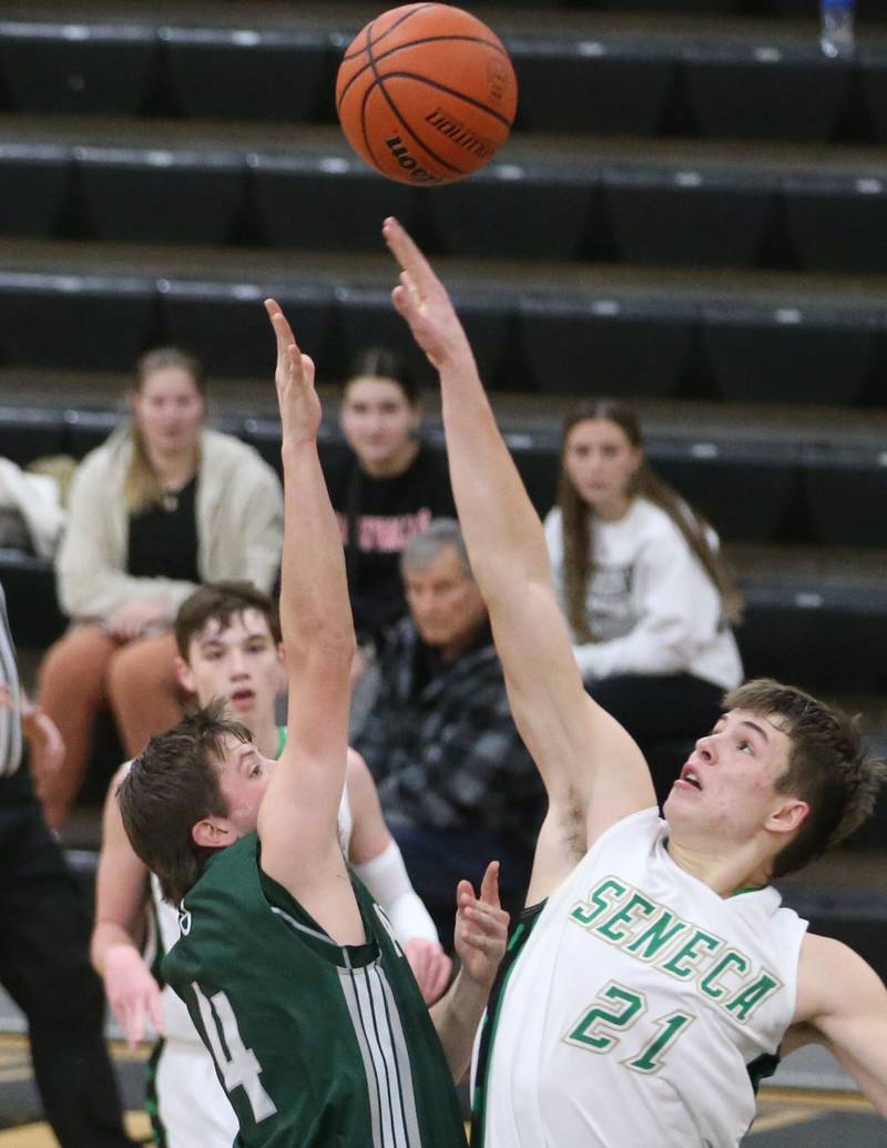 St. Bede's Logan Potthoff and Seneca's Lane Provance tap the ball in the air during a rebound in the Tri-County Conference Tournament on Tuesday, Jan. 23, 2024 at Putnam County High School.