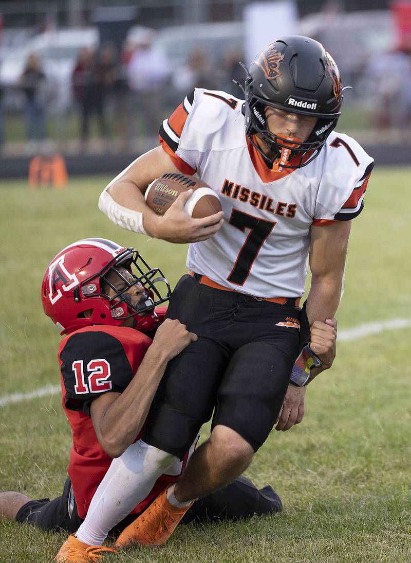 Milledgeville’s Konner Johnson is hauled down by Amboy’s Damion Bender Friday, August 29, 2025, in Amboy.