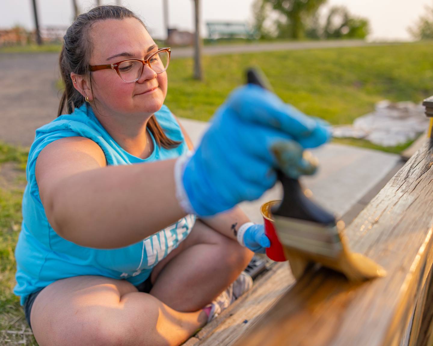 Maci Boles applies stain to a fence surrounding the playground during at Rotary Park on June 1, 2025 in LaSalle.