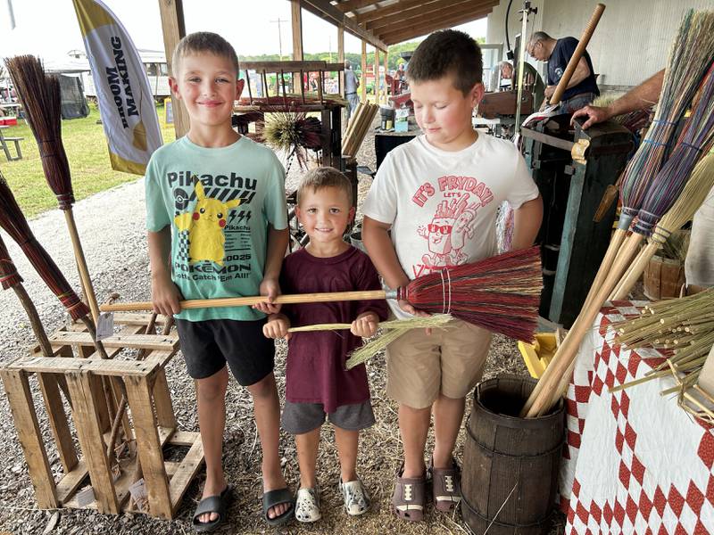 Lincoln, Everett, and Baylor Buckwalter hold the broom Carvel Morgan of Davenport made them by hand  at the Bos Family Farms on Friday, July 25, 2025.
