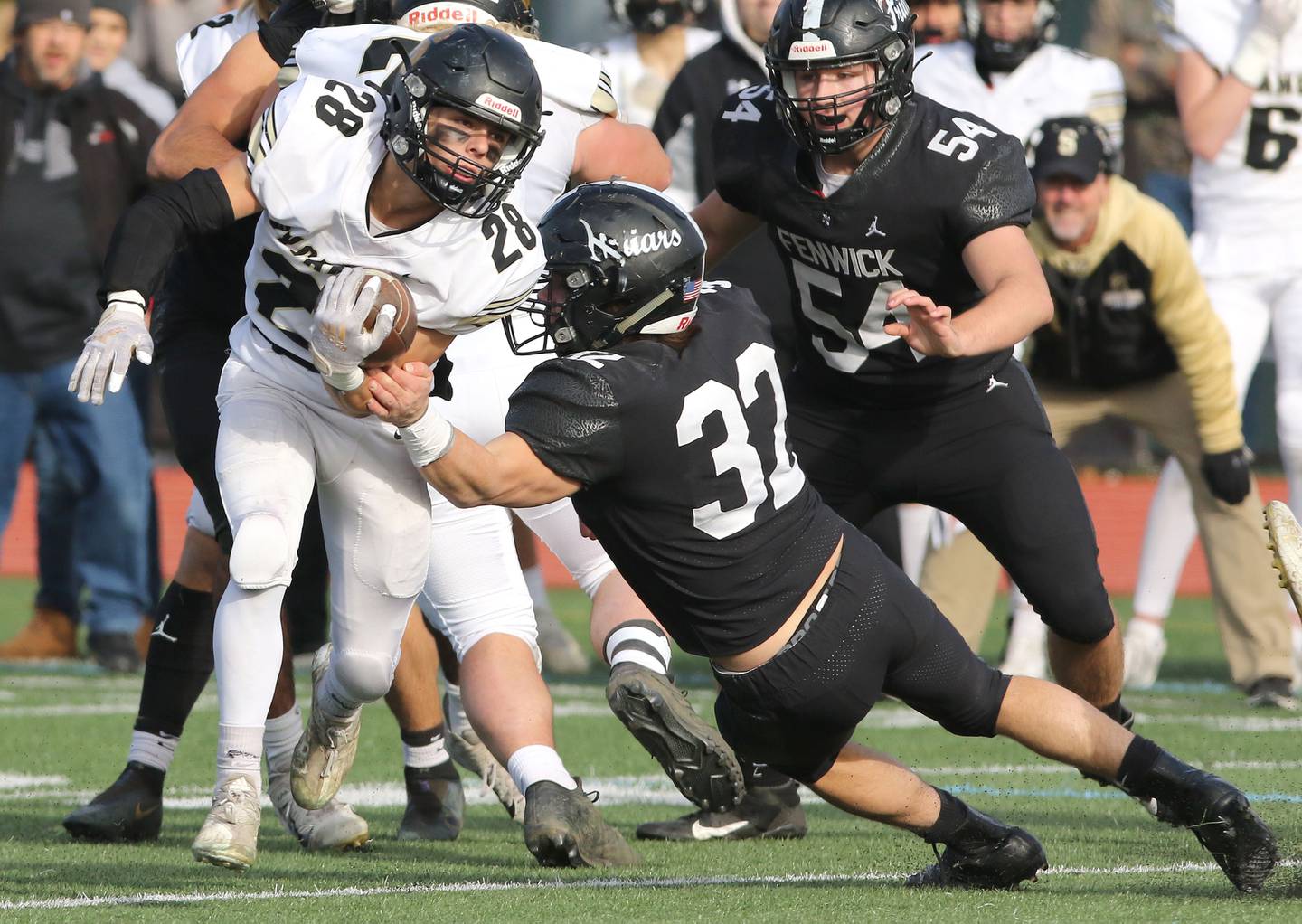 Sycamore's Sam Carlson is pulled down by Fenwick's Conor Paris during their IHSA Class 5A state semifinal game Saturday, Nov. 20, 2021, at Triton College in River Grove.