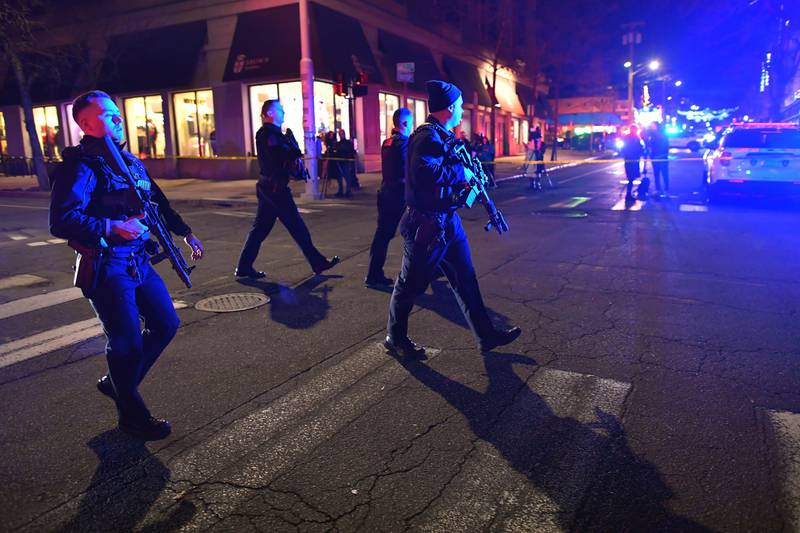 Law enforcement officials carry rifles while walking on a street in a neighborhood near Brown University in Providence, R.I., on Saturday, Dec. 13, 2025 during the investigation of a shooting. (AP Photo/Steven Senne)