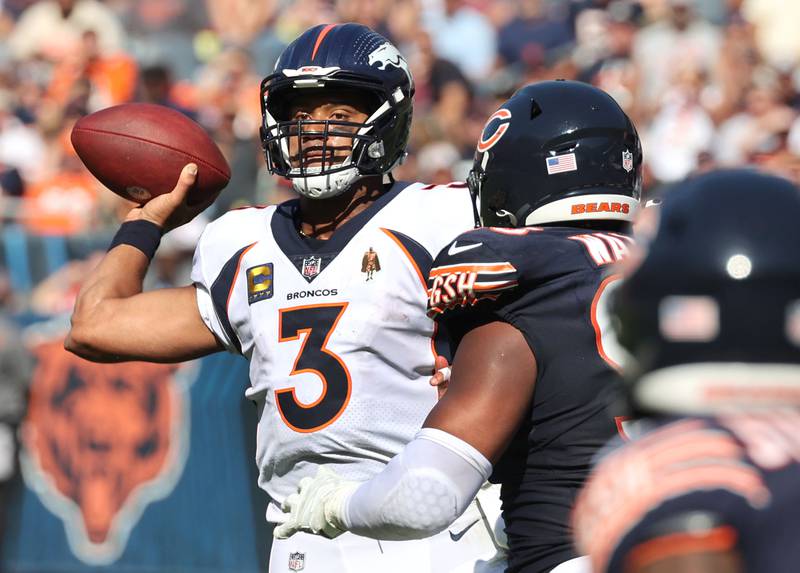 Denver Broncos quarterback Russell Wilson gets the ball off just ahead of the pressure of Chicago Bears defensive end DeMarcus Walker during their game Sunday, Oct. 1, 2023, at Soldier Field in Chicago.