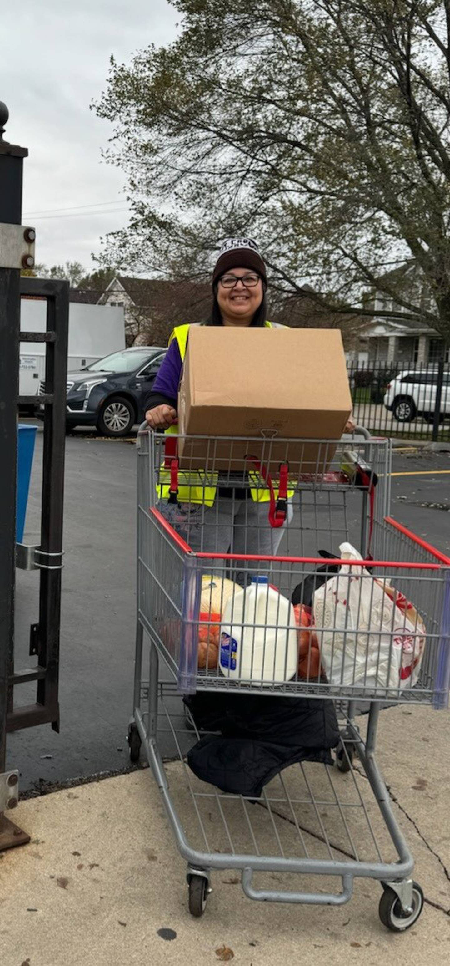 A volunteer at MorningStar Mission, 350 E. Washington St., Joliet, pushes a shopping cart from the food pantry during the Mission's 2024 Thanksgiving food distribution.