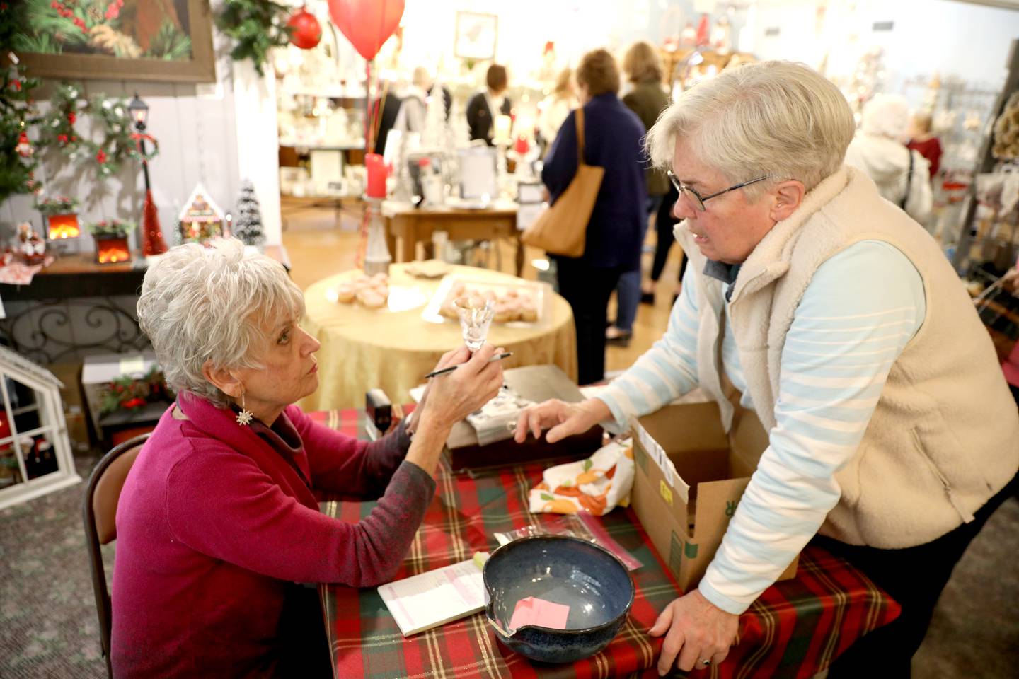 Mary Lou Gates (left) of Mary Lou’s Crystal Repair works with customer Paula von Ende about some of her broken but sentimental glassware during a visit to The Little Traveler in Geneva on Wednesday, Nov. 15, 2023.