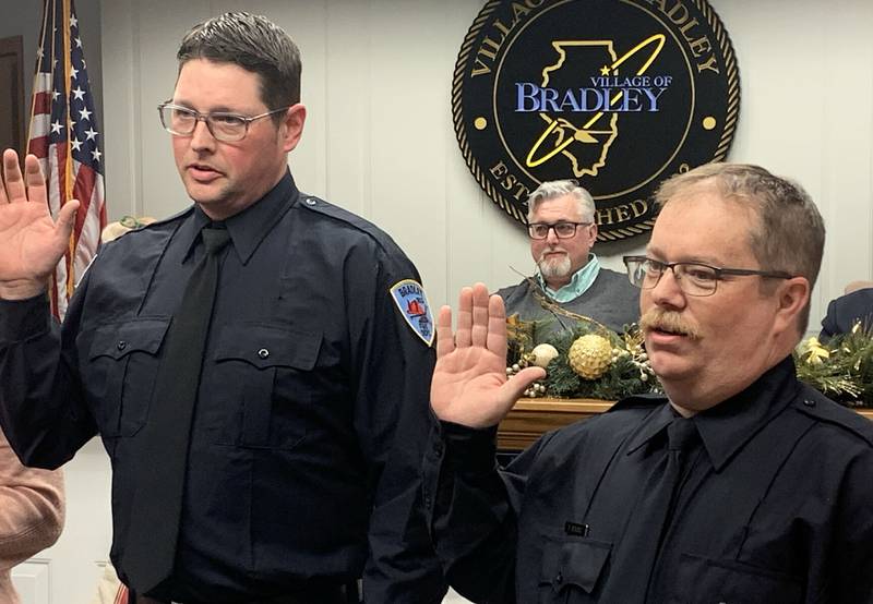 Bradley Fire Department firefighters Greg Devries, left, and Brad Senesac are sworn in at Monday’s Bradley village board meeting.