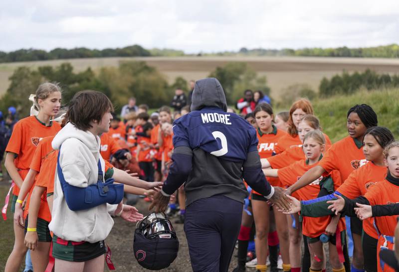Chicago Bears wide receiver DJ Moore (2) runs to practice through an honor gauntlet made up of British school children who were attending a Bears community event. During a training session in Ware, England, Thursday, Oct. 10, 2024, ahead of the game between the Chicago Bears and the Jacksonville Jaguars at Tottenham Hotspur Stadium on Sunday. (AP Photo/Sean Ryan)