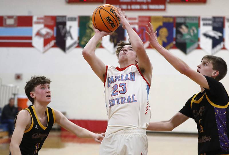 Marian Central's Finn Pivnicka drives to the basket between Chicago Christian's Casey Lenarz (left) and Eddie VanDellen (right) during a Chicagoland Christian Conference basketball game on Tuesday, Jan. 21, 2025, at Marian Central High School.
