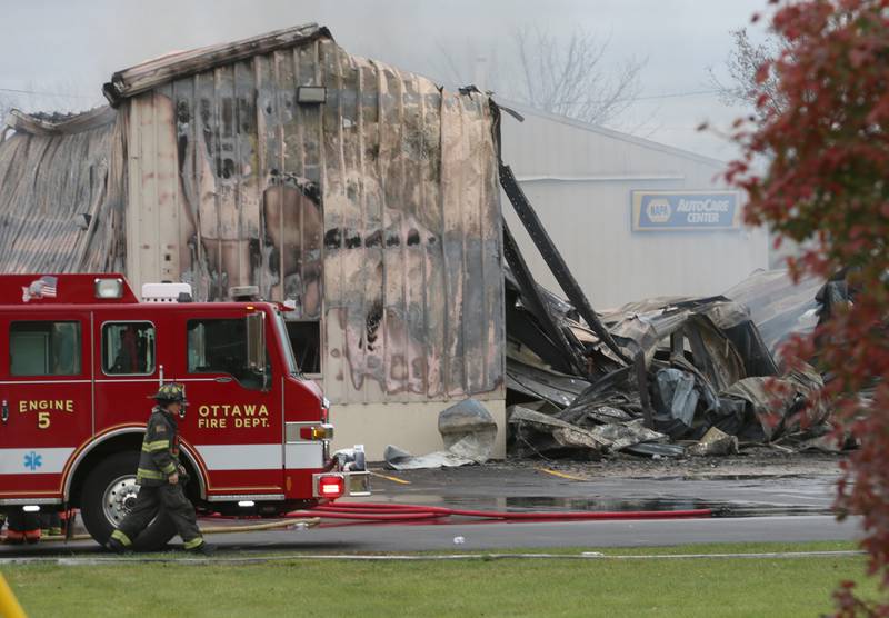 An Ottawa firefighter walks past the scene of a large fire at Conroy's Automotive and 24 Hour Towing building on Wednesday, Nov. 6, 2024 in Ottawa. Fire departments from Wallace, Grand Ridge, Senera, Seneca, Utica and Peru all responded to the blaze.