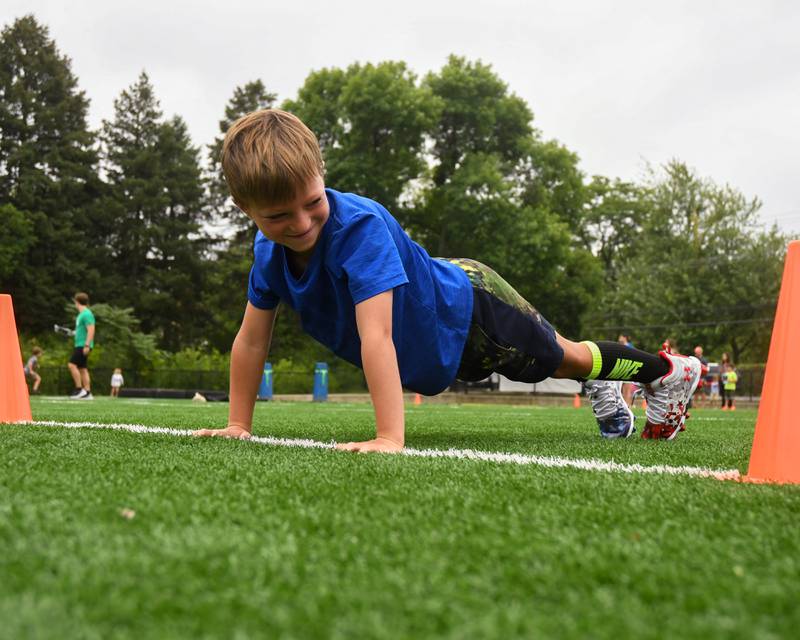 Oliver Drews, 7, of Downers Grove sees how many pushups he can do during the NFL Youth Flag Football Combine Day held at Doerhoefer Park in Downers Grove on Sunday Aug. 6, 2023.