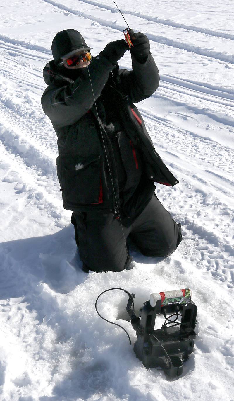 Trevor Janes, who owns Wet N Wild Outfitters, sets the hook on a yellow bass while ice fishing Friday, Feb 3. 2023, on Petite Lake near Fox Lake.