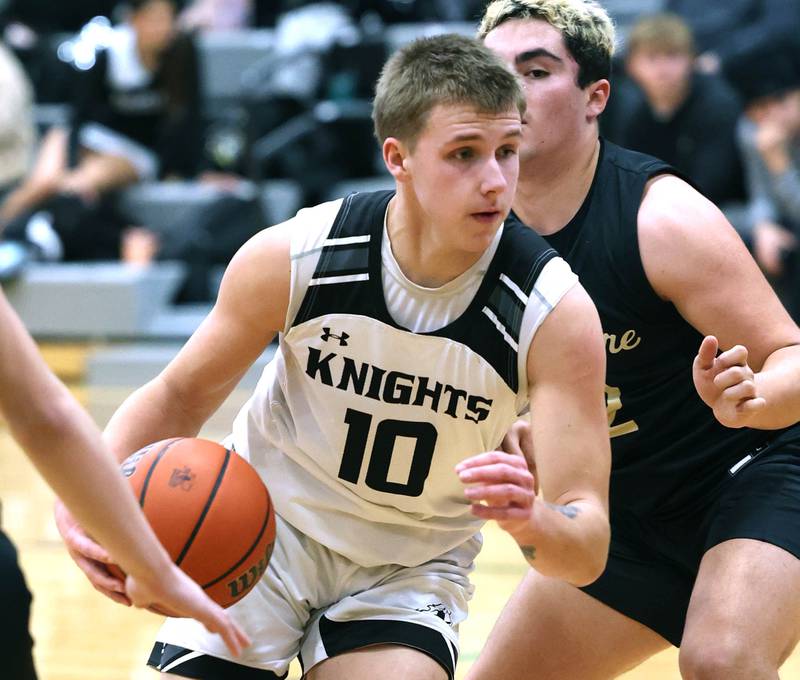 Kaneland's Troyer Carlson drives by Sycamore's Diego Garcia during their game Friday, Jan. 5, 2024, at Kaneland High School in Maple Park.