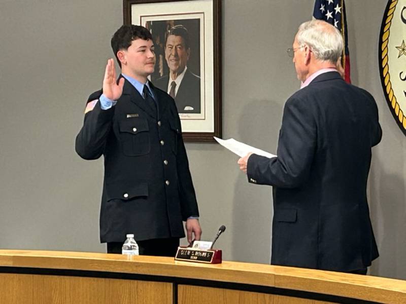 Dixon Mayor Glen Hughes (right) gives the oath of office to Dixon firefighter Evan Munson on Monday at Dixon City Hall.