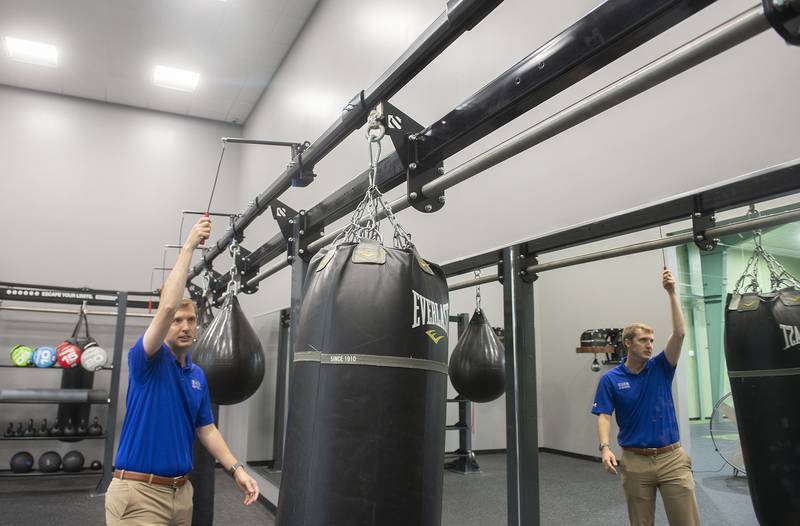 Kel Bond shows how easy it is to move heavy workout equipment in an area of Westwood meant for High Intensity Interval Training (HIIT) exercise. The area has heavy bags, medicine balls and kettle bell options.
