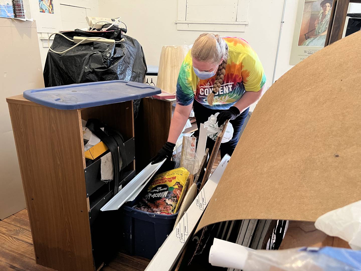 Lisa Shelton sorts through a damp box in the basement of the DeKalb Area Women's Center on Aug. 24, 2022.