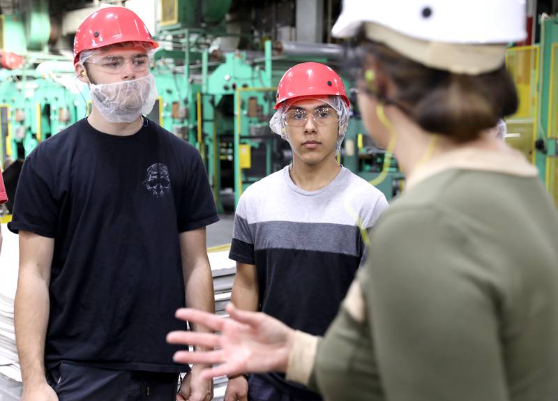 Compass Academy students Thomas Rushing (left) and Hector Garcia (center) tour the Pactiv Evergreen manufacturing facility with Human Resources Manager Jennifer Pesch in St. Charles on Wednesday, Oct. 26, 2022. Compass Academy is a new St. Charles District 303 program that opened in the fall of 2021 at the Haines Center