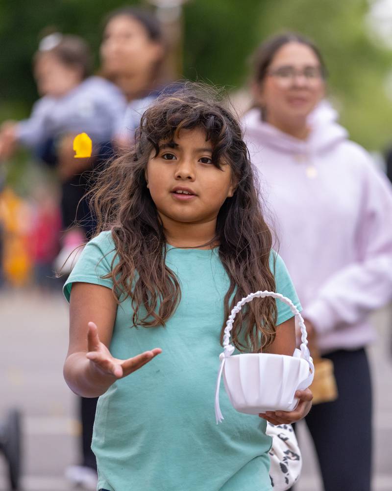 Andrea Picazo tosses a flower pedal in the air during the National Eucharistic Pilgrimage on Monday, May 19, 2025, between St. Hyacinth Church and Queen of the Holy Rosary Shrine in La Salle.