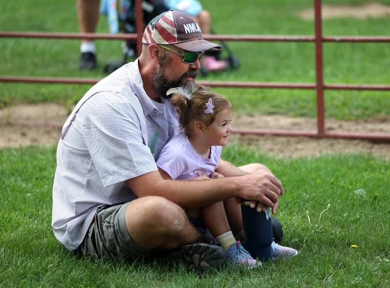 Chase Hanlock and his daughter Sylvie, 3, from Somonauk, watch the barrel racing competition in the horse arena Wednesday, Sept. 3, 2025, on opening day of the Sandwich Fair.