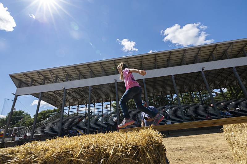Nora Heid, 7, of Pearl City successfully navigates the balance beam Saturday, Aug. 10, 2024 in the Ninja Farmer course at the Carroll County Fair.