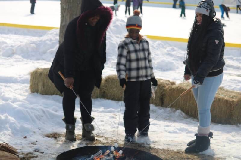 Krystal Scott (left), Carl Scott and Zakaya Scott (right) roast s'mores over an open fire during the DeKalb Park District's seventh annual Polar Palooza held Saturday, Feb. 4, 2023.