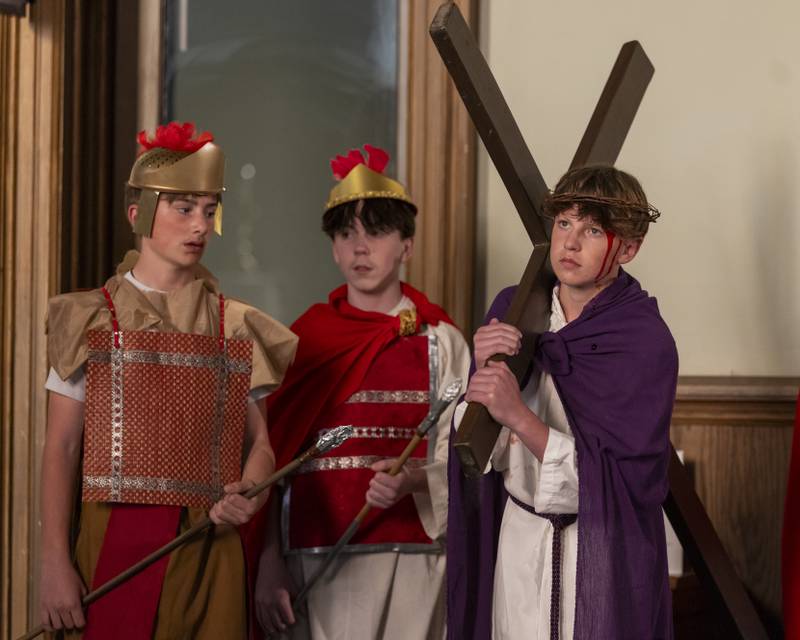 Condemned to death, Jesus portrayed by Bruno Baker carries his cross during the Stations of The Cross event on April 16, 2025 at St. Patrick's Church.