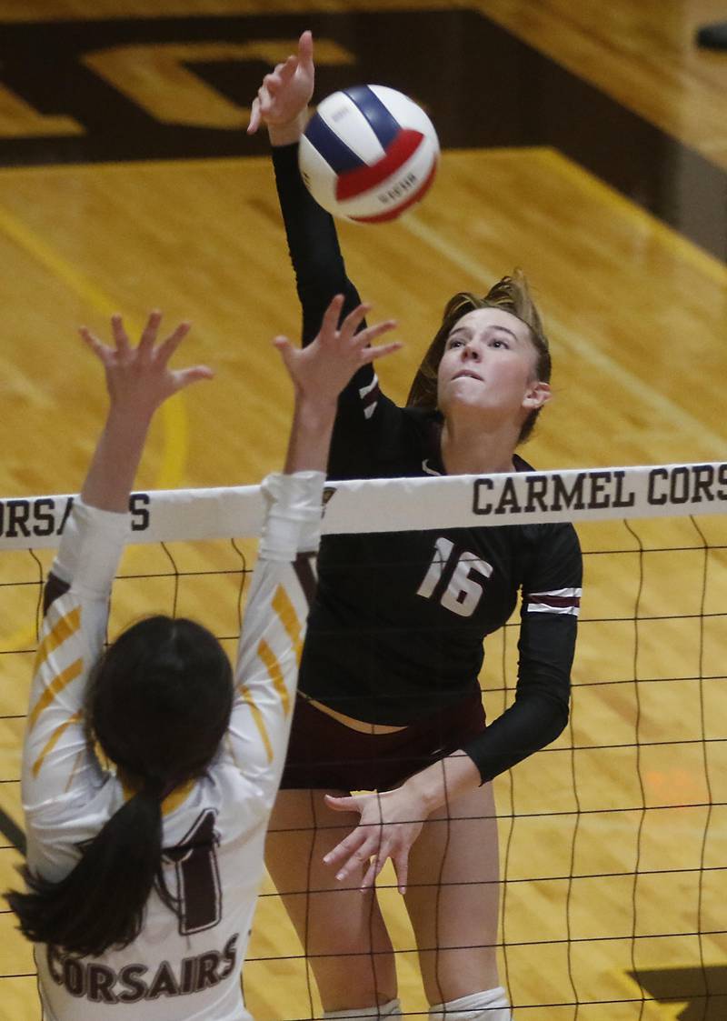 Prairie Ridge's Addy Grider (right) hits the ball away from the block of Carmel’s Charlotte Shepherd and down the line during the IHSA Class 3A Carmel Sectional championship volleyball match on Thursday, Nov. 6, 2025, at Carmel High School, in Mundelein.