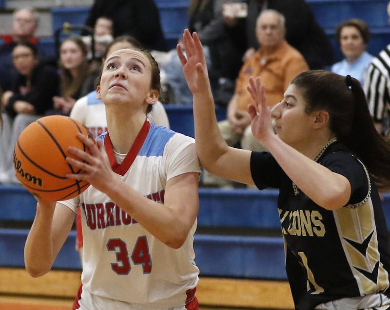 Marian Central's Juliette Huff drives to the basket between Rockford Christian's Lucy Gargani during a nononference basketball game on Monday, Feb. 10, 2025, at Marian Central High School  in Woodstock.