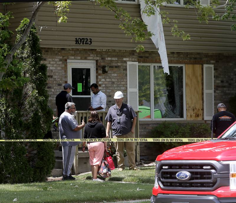 Patrick Woolbright, from the village of Huntley, talks with building residents on Thursday, July 13, 2023, after a confirmed tornado took the roof off an apartment building in Huntley on Wednesday.