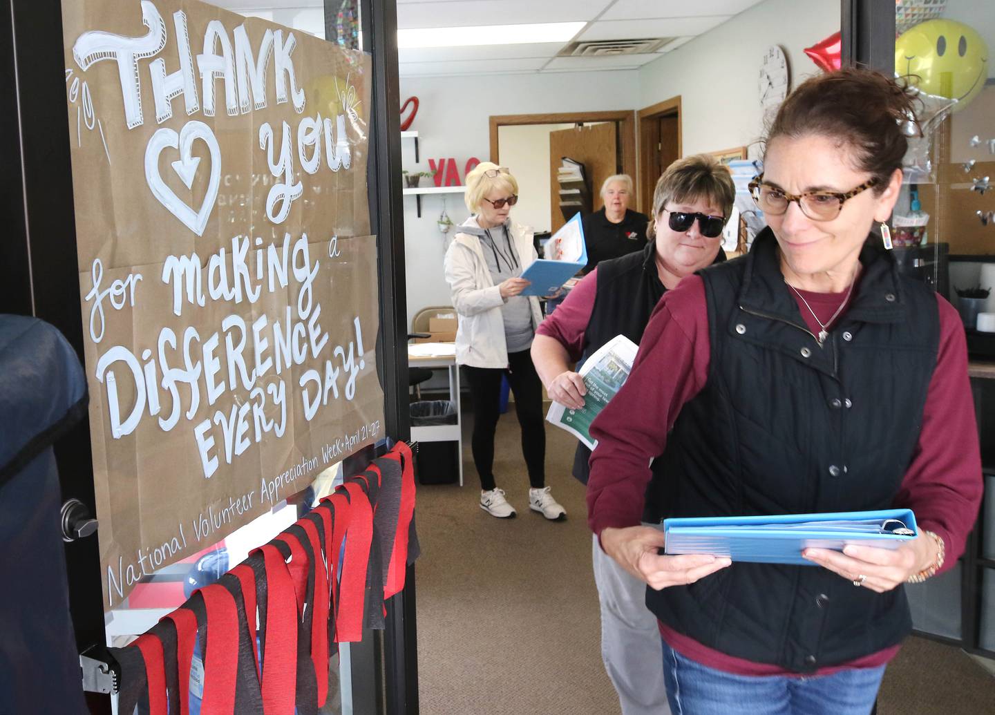 Volunteers Chris Sauter (right) and Steffanie Barringer, (second from right) both from DeKalb, pick up a Meals on Wheels delivery to distribute Tuesday, April 23, 2024, at the Voluntary Action Center in Sycamore. VAC is celebrating its 50th anniversary this year.