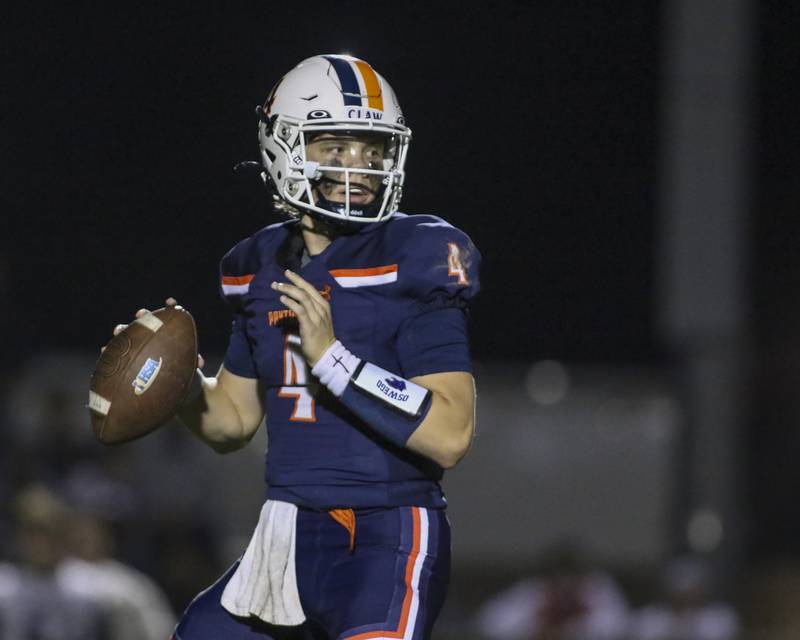 Oswego's Drew Kleinhans (4) looks for an open receiver during football game between Oswego East at Oswego Friday, Oct 17, 2025 in Oswego.