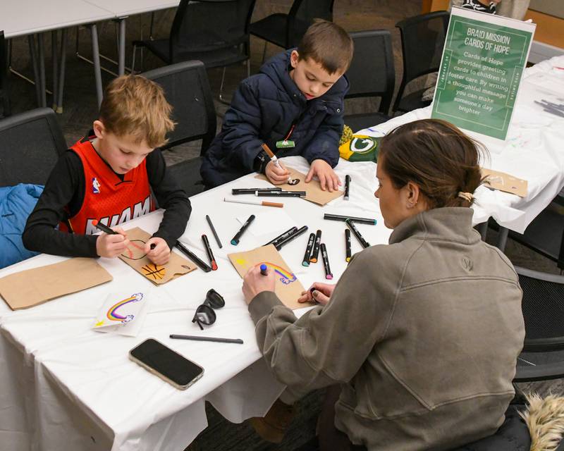Jack Vurdelja, 9, left, Liam Vurdelija, 7, and Mom Vurdelja of Elmhurst color paper lunch bags on Monday Jan. 20, 2025, that will be donated and use for Meals on Wheels during the Martin Luther Kin Jr. Day of Service.