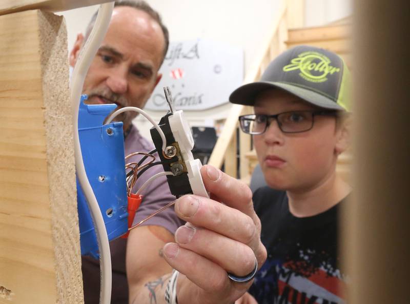 Mat Dawson electronics instructor teaches Chris Znaniecki how to wire an outlet during the Area Career Center Hands-On Showcase on Thursday, June 8, 2023 at La Salle-Peru Township High School.