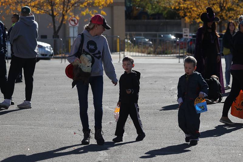 A family walks through the Joliet Police Department parking lot collecting candy at the Joliet Police Department Trunk-Or-Treat event on Saturday, Oct. 26, 2024 in Joliet.