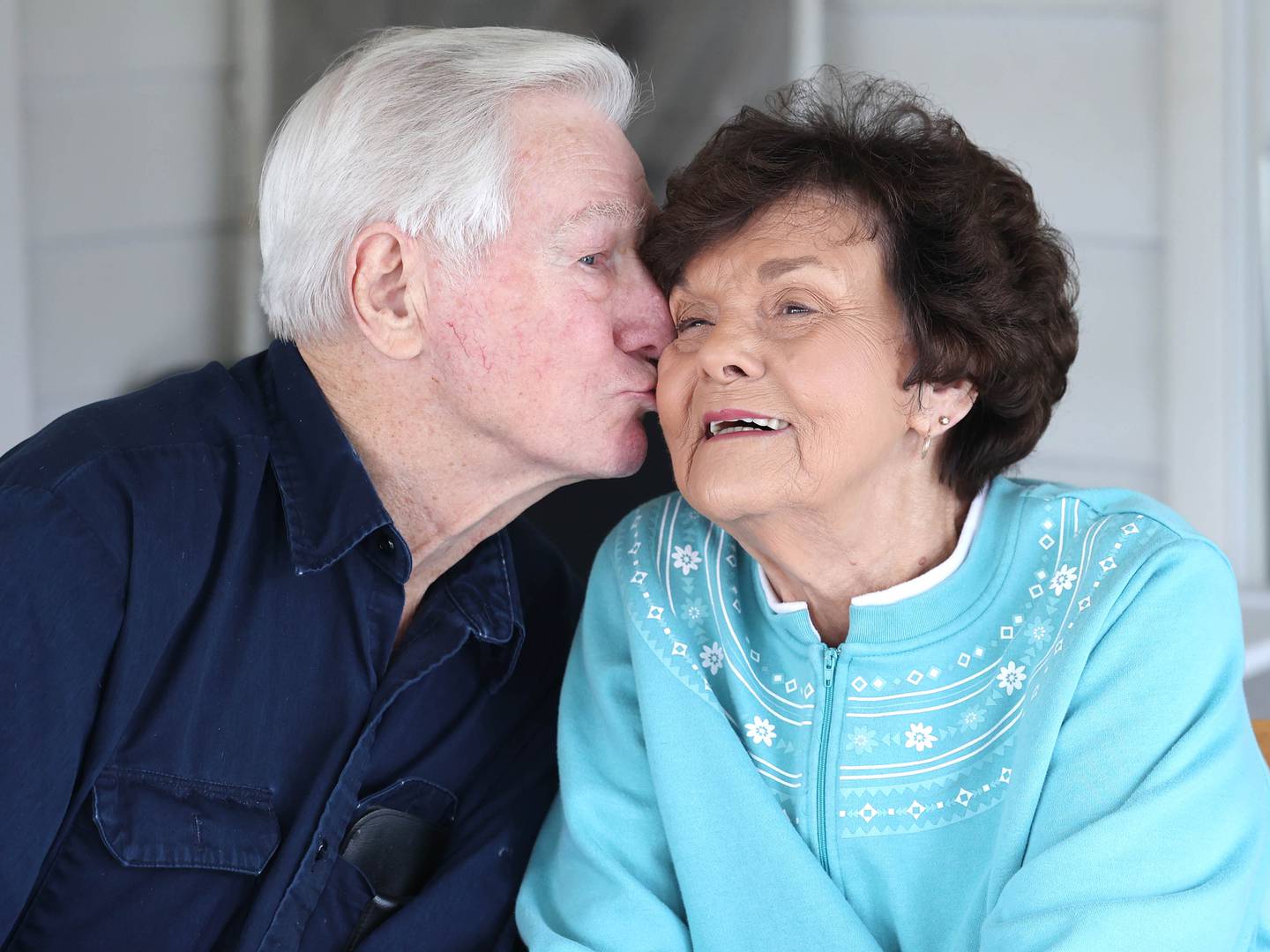 Morry Drury plants a kiss on his wife Joan’s cheek Thursday, Feb. 9, 2023, at their home in DeKalb. The couple celebrated their 70th wedding anniversary in Sept. of last year.