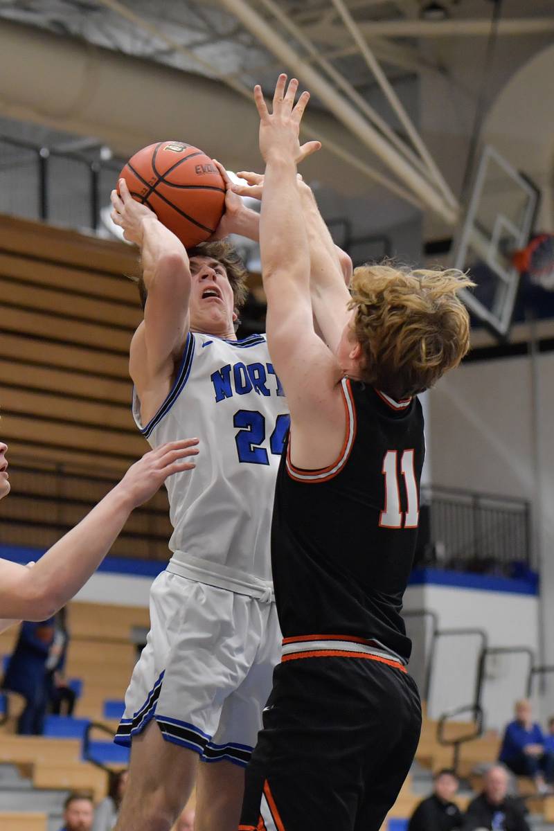 St. Charles North's Colin Ross (24) takes a shot over Wheaton Warrenville South Colin Moore (11) during a game on Friday, December 2, 2022.