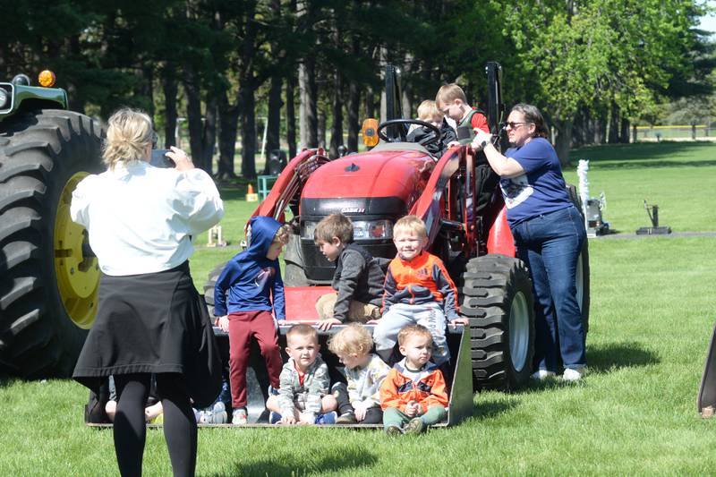 Oregon Elementary School students pose for a photo in the bucket of one of the farm machines on display at the Oregon High School's FFA ag event on Friday, May 9, 2025.