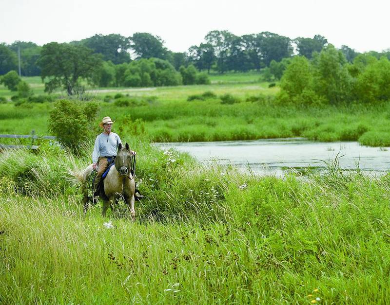 Siegfried Greiner of Cary rides his horse, Blue, through Glacial Park in Ringwood on Monday, July 26, 2010.
