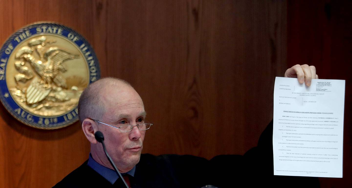 Judge Mark Gerhardt shows a document as he presides over a hearing for defendants Colin Scott and Michael Penkava Thursday, Dec. 16, 2021, at the Michael J. Sullivan Judicial Center in Woodstock.