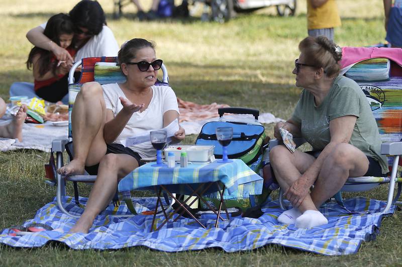 Eva and Eta Vig of Algonquin talk before the start of the Crystal Lake Park District's Concert in the Park on Tuesday, June 17, 2025, at Main Beach in Crystal Lake. The concert was part of the park district's weekly Tuesday night summer concert series.