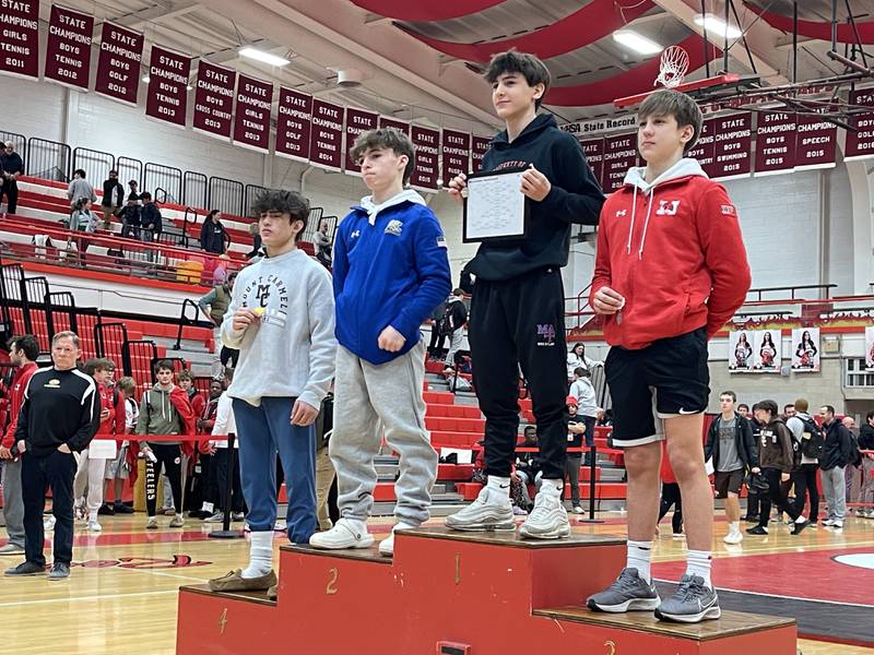 Marmion freshman Nick Garcia at the podium following his 106-pound first place finish at the Class 3A Hinsdale Central sectional wrestling meet on Saturday. Photo by Jake Bartelson.