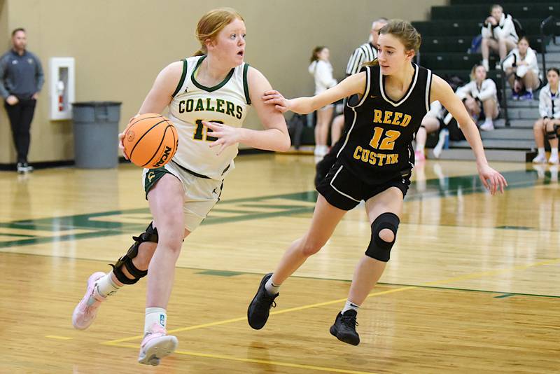 Coal City's Jori Tucker, left, brings the ball up the floor as Reed-Custer's Gwen Stewart defends during an IHSA Class 2A Coal City Regional semifinal Tuesday, Feb. 18, 2025.