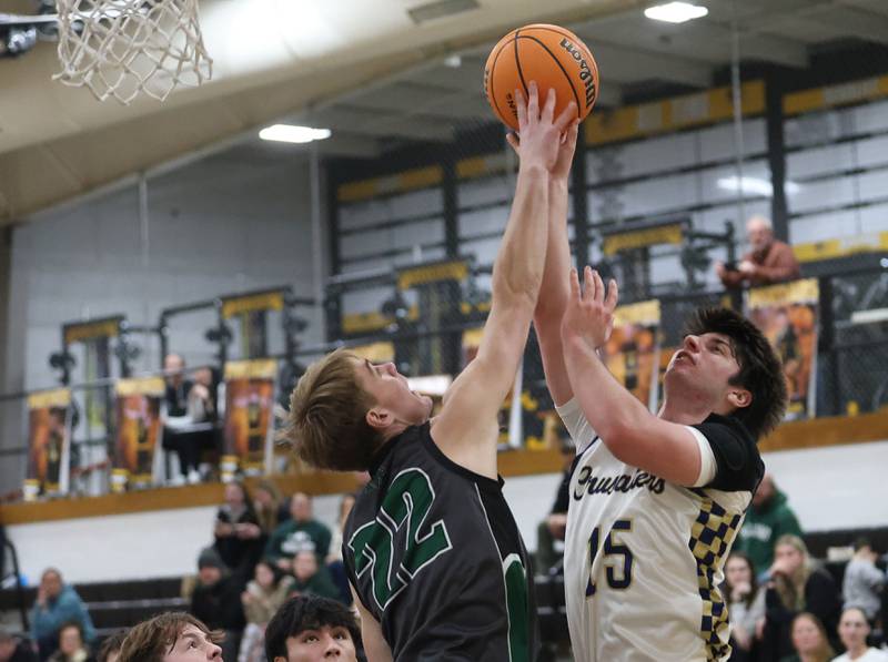 Marquette's Alec Novotney lets go of a shot under the hoop as Midland's Trent Allen gets a piece of it it with his finger tips during the Tri-County Conference Tournament on Monday, Jan. 26, 2026 at Putnam County High School